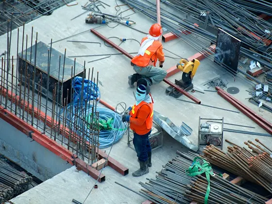 Bouwvakkers werken aan een betonnen constructie met wapeningsstaal.